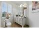 Well-lit bathroom featuring white cabinetry, marble countertop, and a large window with plantation shutters at 9044 Riverbend Manor, Alpharetta, GA 30022