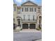 Charming townhome showcasing a two-car garage, lovely windows, and a classic brick facade at 9044 Riverbend Manor, Alpharetta, GA 30022