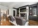 Cozy living room showcasing a fireplace, dark built-in shelving, and comfortable seating at 9044 Riverbend Manor, Alpharetta, GA 30022