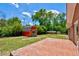 View of a backyard, showcasing a red storage shed, green lawn, and a brick patio at 1840 Linwood Ave, Atlanta, GA 30344