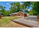 Expansive backyard with a brick patio, lush lawn, and a charming red storage shed at 1840 Linwood Ave, Atlanta, GA 30344