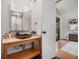 Bright bathroom vanity with stone sink and wood cabinet; features shower and closet in background at 2568 Sugarplum Ne Ct, Atlanta, GA 30345