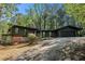 One story home with a black exterior, stone accents, a paved driveway, and mature trees at 2568 Sugarplum Ne Ct, Atlanta, GA 30345
