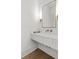 Powder room featuring a marble countertop, gold faucet, and a rectangular mirror above the sink at 52 25Th Nw St, Atlanta, GA 30309
