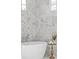 Luxury bathroom with white freestanding tub, marble tile, and natural light from windows at 52 25Th Nw St, Atlanta, GA 30309