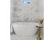 Freestanding tub with marble tile and windows for natural light in elegant bathroom at 52 25Th Nw St, Atlanta, GA 30309