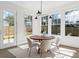 Dining room features round wood table, modern lighting, large windows, and access to backyard at 52 25Th Nw St, Atlanta, GA 30309