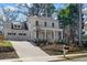 Elegant two-story white home with a covered porch, beautiful landscaping, and a spacious two-car garage at 52 25Th Nw St, Atlanta, GA 30309
