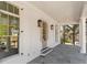 Inviting front porch with stone flooring, white columns, and elegant lighting fixtures providing curb appeal at 52 25Th Nw St, Atlanta, GA 30309