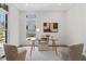 Bright home office featuring a modern glass desk, comfortable seating, and a large window for natural light at 52 25Th Nw St, Atlanta, GA 30309