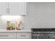 Kitchen featuring white cabinets, stainless steel range, marble countertops, and subway tile backsplash at 52 25Th Nw St, Atlanta, GA 30309