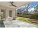 Covered patio featuring a ceiling fan, stone floor, white brick columns, and views of the backyard at 52 25Th Nw St, Atlanta, GA 30309
