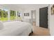 Cozy bedroom with large windows, a dresser, and a glimpse of an en-suite bathroom at 10940 Serenbe Ln, Chattahoochee Hills, GA 30268