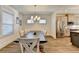 Dining room with an expansive dining table with seating for eight illuminated by a modern light fixture at 2225 Nena Way, Tucker, GA 30084
