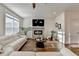 Bright living room featuring modern fireplace, tv, hardwood floors, and white sofa at 2225 Nena Way, Tucker, GA 30084