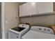 Laundry room featuring a washer, dryer, and overhead storage cabinets at 30 Plantation Ne Dr # B, Atlanta, GA 30324