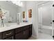 Well-lit bathroom featuring a granite vanity, decorative wall art, and an adjacent shower/tub at 3172 Havencroft Ne Dr, Roswell, GA 30075