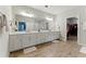 Bathroom boasting double vanities with modern fixtures, wood-style flooring and an adjacent walk-in closet at 3172 Havencroft Ne Dr, Roswell, GA 30075