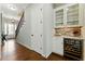 Hallway with hardwood floors, staircase, and built-in wine storage and display at 3172 Havencroft Ne Dr, Roswell, GA 30075