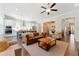 Spacious living room featuring hardwood floors, a ceiling fan, a leather sofa, and an open kitchen at 3172 Havencroft Ne Dr, Roswell, GA 30075