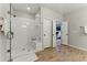 Modern bathroom with glass-enclosed shower, white subway tiles, and wood-look floor tiling at 3172 Havencroft Ne Dr, Roswell, GA 30075
