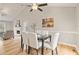 Cozy dining area featuring hardwood floors, soft white chairs, and an archway that leads to the living room at 7170 Highbrook E Cir, Cumming, GA 30041