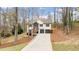 Charming two-story home featuring a two-car garage, front porch, and a lush, wooded landscape at 7170 Highbrook E Cir, Cumming, GA 30041