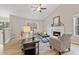 Bright living room with a fireplace, a ceiling fan and large windows offering natural light at 7170 Highbrook E Cir, Cumming, GA 30041