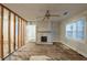 Bright living room with fireplace, ceiling fan and window, showing renovation in progress at 1753 Beechwood Sw Blvd, Atlanta, GA 30311