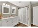 Updated bathroom with dual vanity, framed mirrors, a shower and modern lighting at 214 Walton St, Loganville, GA 30052
