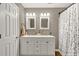 Updated bathroom with dual vanity, framed mirrors, a shower and modern lighting at 214 Walton St, Loganville, GA 30052