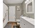 Bright bathroom featuring a double sink vanity, decorative shower curtain, and wood-look floors at 214 Walton St, Loganville, GA 30052
