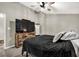 Neutral bedroom with a black bedspread, ceiling fan, and a dresser with TV at 214 Walton St, Loganville, GA 30052