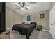 Bedroom features a black bedspread, ceiling fan, an accent table and wall art at 214 Walton St, Loganville, GA 30052