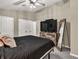 Neutral bedroom with a black bedspread, ceiling fan, and a dresser with TV at 214 Walton St, Loganville, GA 30052