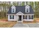 Charming two-story home with black shutters and dormer windows, set against a backdrop of lush trees at 214 Walton St, Loganville, GA 30052