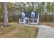 A charming two-story home surrounded by trees with a driveway leading up to the front of the house at 214 Walton St, Loganville, GA 30052