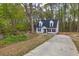 Charming two-story home with a spacious driveway surrounded by lush greenery and tall trees at 214 Walton St, Loganville, GA 30052