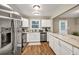 Open kitchen with white cabinets, stainless appliances, and stone countertops at 214 Walton St, Loganville, GA 30052