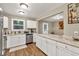 Renovated kitchen with white cabinets, stainless appliances, and stone countertops at 214 Walton St, Loganville, GA 30052