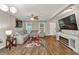 Cozy living room with gray sectional, wood-look floors, a modern TV console, and decorative lighting at 214 Walton St, Loganville, GA 30052