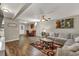 Bright living room featuring a comfortable gray sectional, wood floors, and stylish decor at 214 Walton St, Loganville, GA 30052