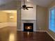 Cozy living room with a burning fireplace, hardwood floors, and a view into the dining area at 2368 Barrett Cottage # 17, Marietta, GA 30066