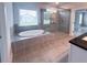 Bright bathroom featuring a soaking tub, a glass-enclosed shower and tile flooring at 3292 Lions Ruby Ln, Atlanta, GA 30349
