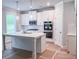 Bright kitchen featuring white cabinets, stainless steel appliances, and a spacious island with pendant lighting at 3292 Lions Ruby Ln, Atlanta, GA 30349
