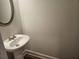 Elegant powder room featuring pedestal sink, stylish mirror, and modern fixtures at 3292 Lions Ruby Ln, Atlanta, GA 30349