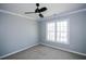 Neutral bedroom with carpet flooring, a ceiling fan, and a window offering natural lighting at 5712 Kendrick Ln, Cumming, GA 30041