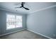 Carpeted bedroom with neutral walls, a ceiling fan, and a window providing natural light at 5712 Kendrick Ln, Cumming, GA 30041