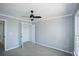 Carpeted bedroom with light gray walls, a ceiling fan, closet and a window overlooking the outdoors at 5712 Kendrick Ln, Cumming, GA 30041