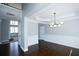 Dining room showcasing hardwood floors and a modern light fixture, open to other spaces at 5712 Kendrick Ln, Cumming, GA 30041